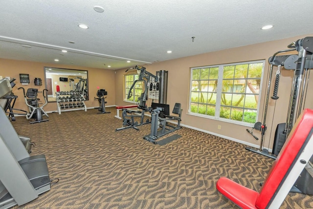 exercise room with carpet flooring and a textured ceiling