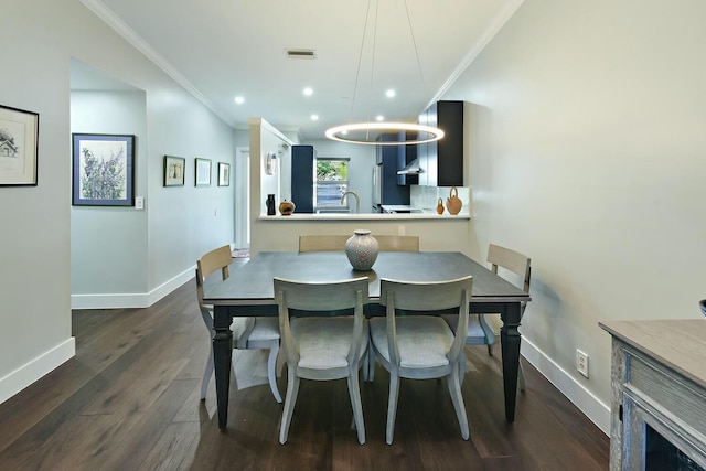 dining room with dark hardwood / wood-style floors, sink, and crown molding