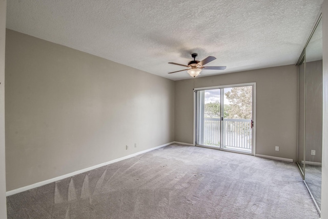 spare room with a textured ceiling, ceiling fan, and light carpet