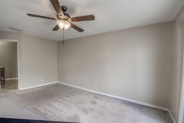 carpeted empty room featuring ceiling fan and a textured ceiling