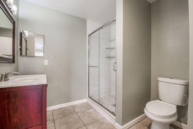 bathroom featuring tile patterned flooring, vanity, toilet, and a shower with door