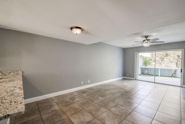 tiled spare room featuring ceiling fan and a textured ceiling