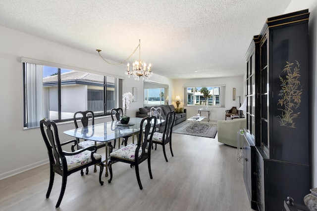 dining area featuring hardwood / wood-style flooring, a textured ceiling, and a chandelier