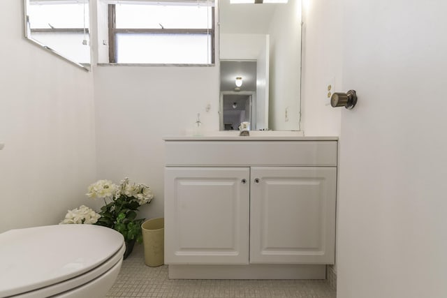 bathroom with tile patterned flooring, vanity, and toilet