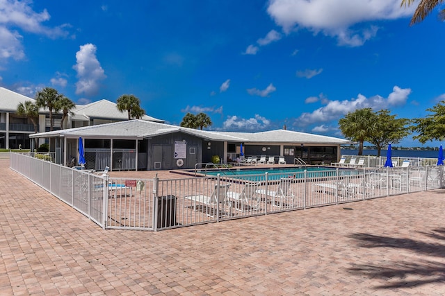 view of pool with a water view and a patio