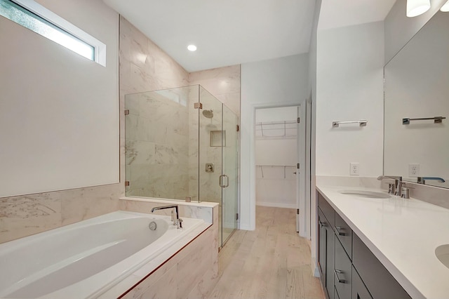 bathroom with hardwood / wood-style floors, vanity, and independent shower and bath