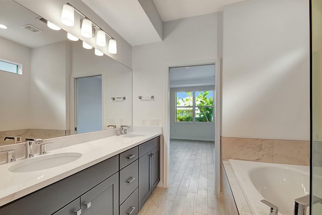 bathroom featuring a tub to relax in, vanity, and hardwood / wood-style flooring