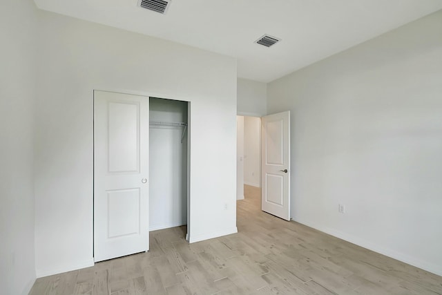 unfurnished bedroom featuring light hardwood / wood-style floors and a closet