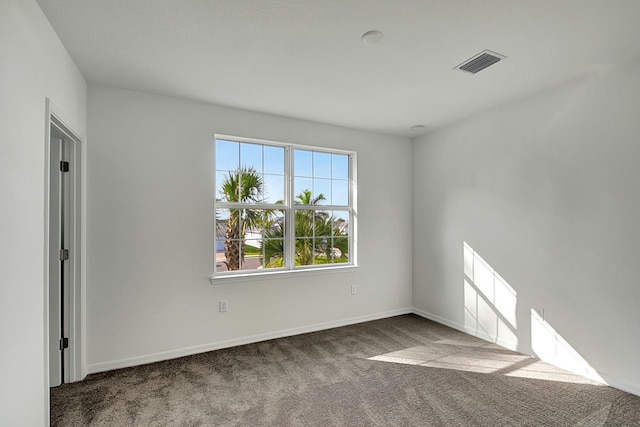 spare room with dark colored carpet