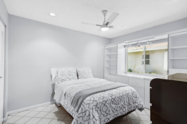 bedroom featuring ceiling fan, light tile patterned floors, a textured ceiling, and a closet