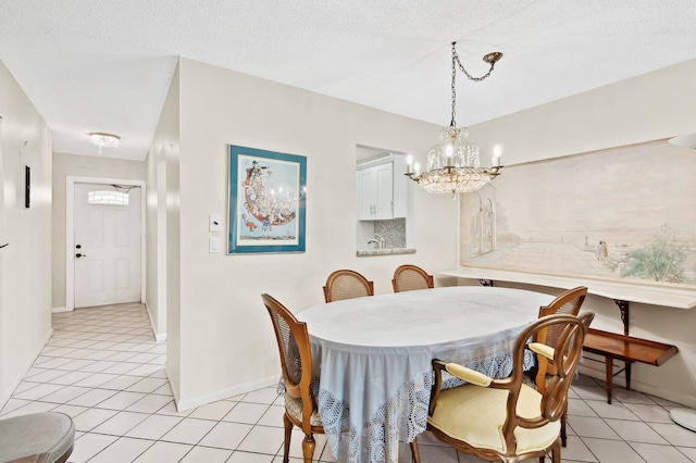 dining space featuring a chandelier, light tile patterned floors, and a textured ceiling