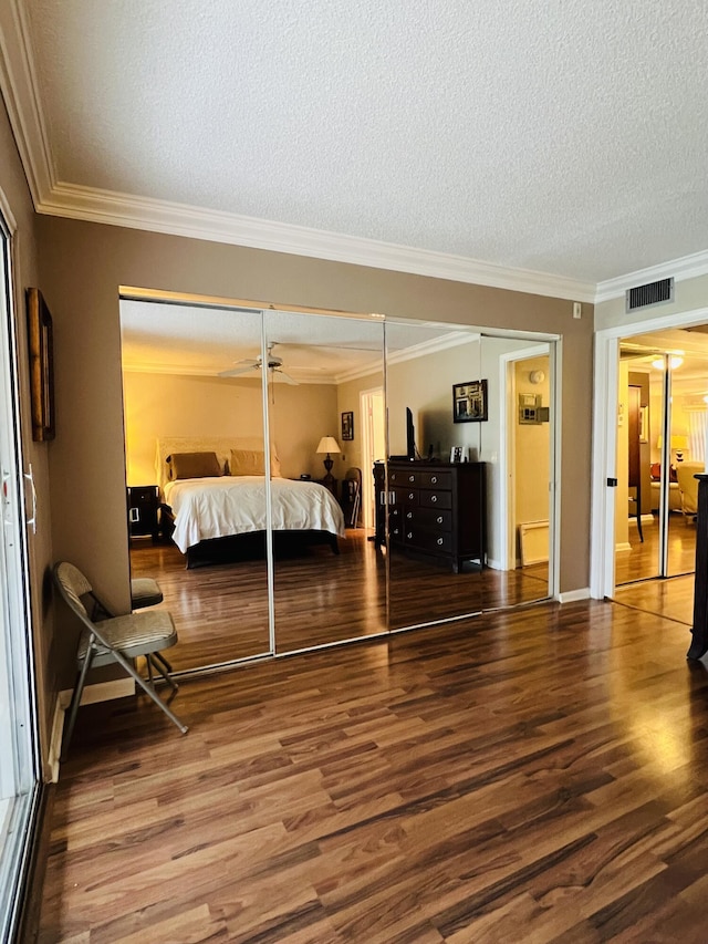 bedroom featuring wood-type flooring, a textured ceiling, and crown molding