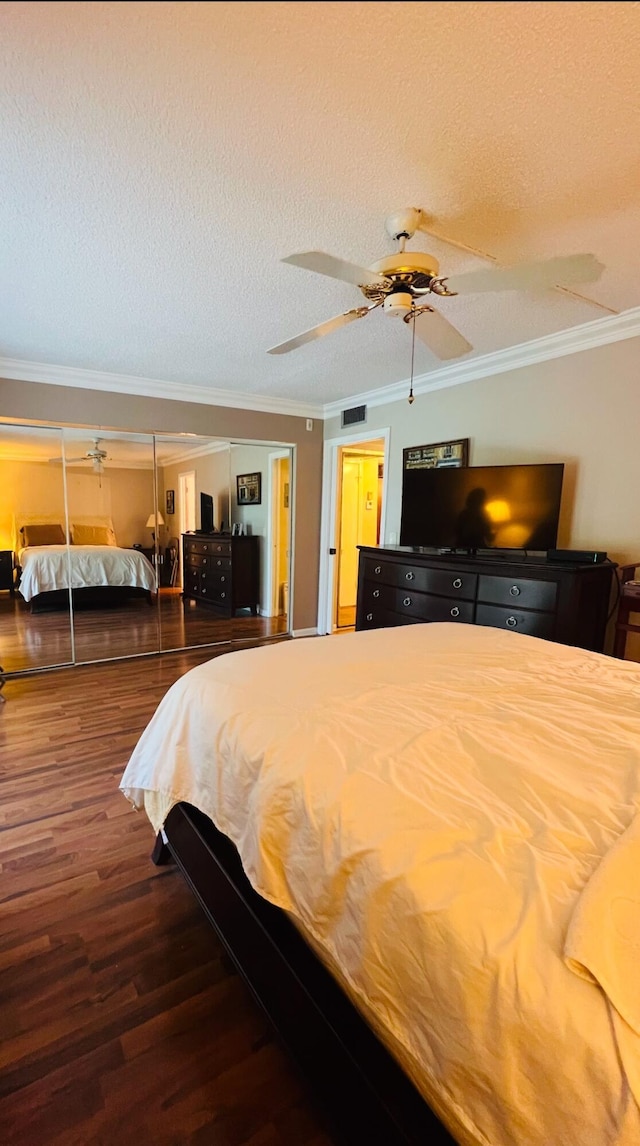 bedroom with ceiling fan, crown molding, a textured ceiling, and hardwood / wood-style flooring