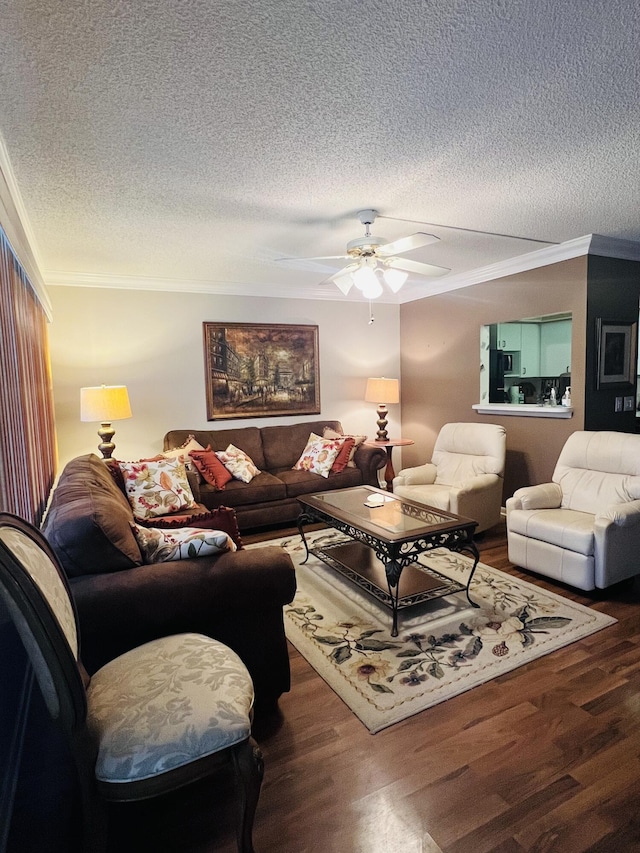 living room with hardwood / wood-style floors, ceiling fan, ornamental molding, and a textured ceiling