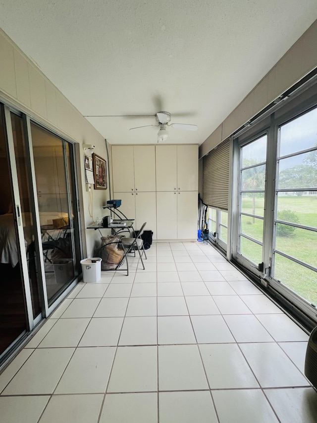 unfurnished sunroom with ceiling fan