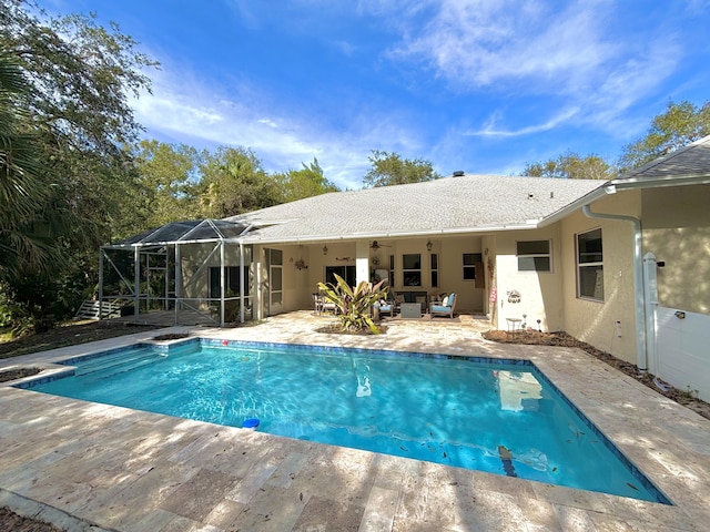 view of pool with a lanai, a patio area, and ceiling fan