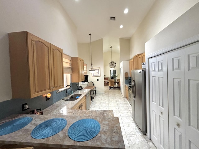 kitchen with sink, stainless steel appliances, high vaulted ceiling, kitchen peninsula, and decorative light fixtures