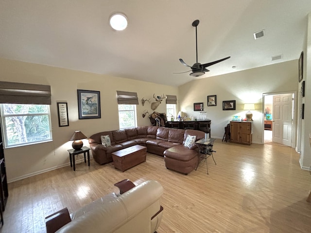 living room featuring light hardwood / wood-style floors, vaulted ceiling, and ceiling fan