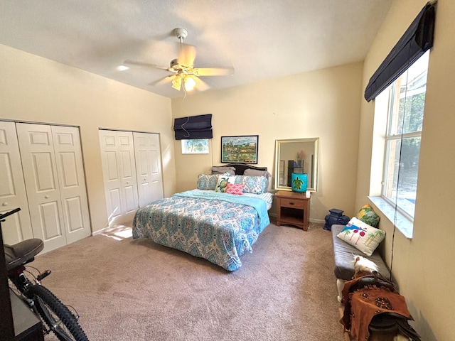 bedroom with carpet flooring, two closets, and ceiling fan