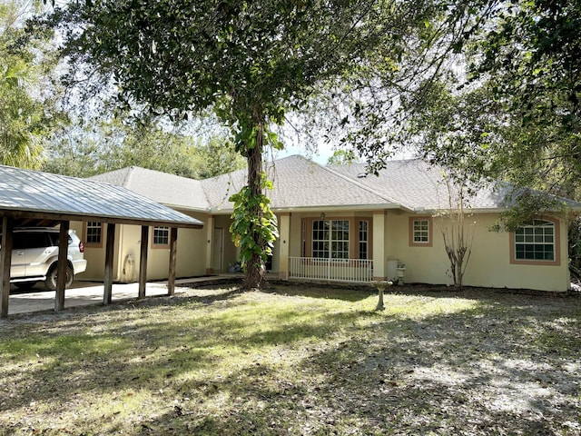 rear view of property featuring a carport and a lawn