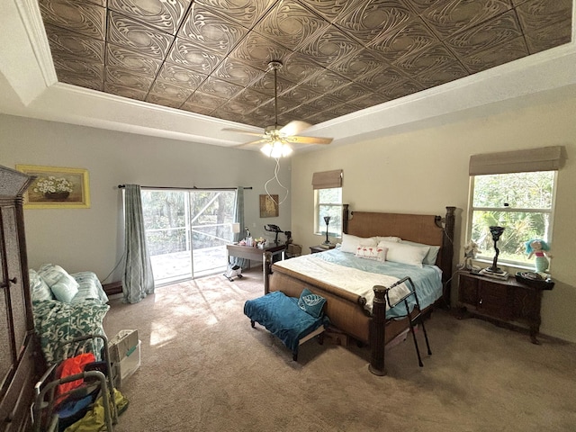 bedroom with access to exterior, carpet flooring, a raised ceiling, ceiling fan, and crown molding