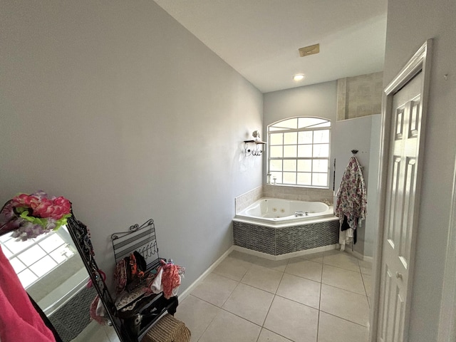 bathroom with tile patterned floors and tiled bath