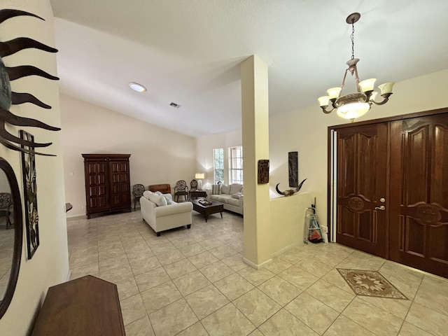 foyer with light tile patterned floors, vaulted ceiling, and an inviting chandelier