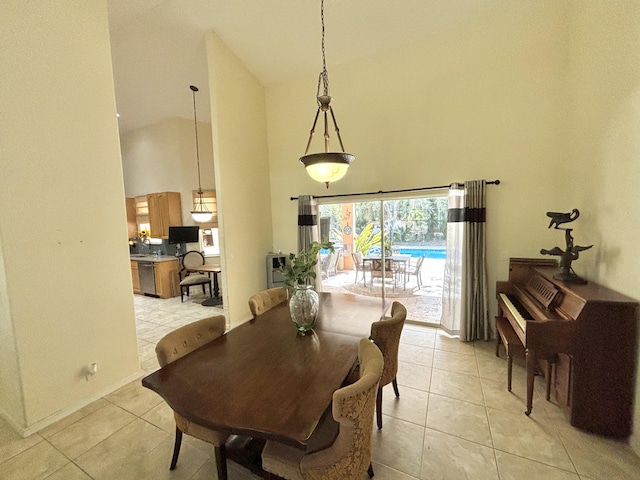 tiled dining space with a towering ceiling