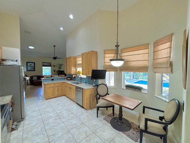 kitchen featuring sink, ceiling fan, appliances with stainless steel finishes, decorative light fixtures, and kitchen peninsula