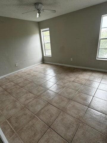 unfurnished room featuring a textured ceiling, plenty of natural light, and ceiling fan