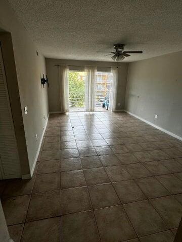 empty room featuring ceiling fan and a textured ceiling