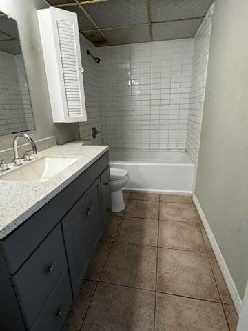 full bathroom featuring tile patterned flooring, vanity, toilet, and tiled shower / bath combo