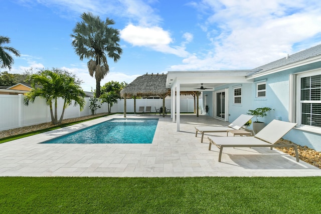 view of pool with a lawn, a patio area, and ceiling fan