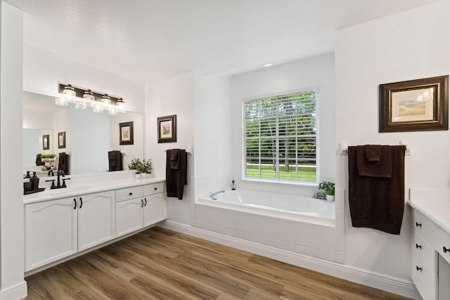 bathroom featuring hardwood / wood-style floors, vanity, and a bath