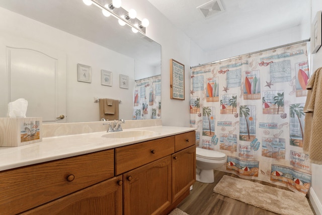 bathroom featuring a shower with curtain, vanity, hardwood / wood-style flooring, and toilet