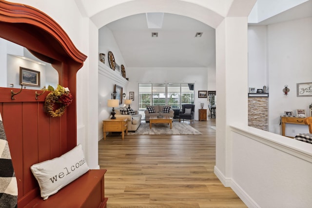 hallway featuring light hardwood / wood-style floors and vaulted ceiling