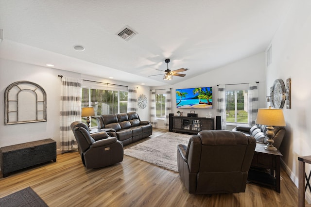 living room featuring hardwood / wood-style floors, ceiling fan, and vaulted ceiling