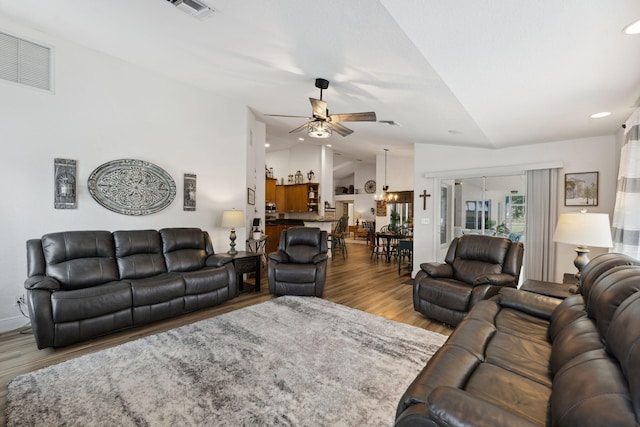 living room with wood-type flooring, vaulted ceiling, and ceiling fan