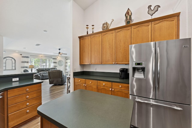 kitchen with appliances with stainless steel finishes, light hardwood / wood-style flooring, and ceiling fan