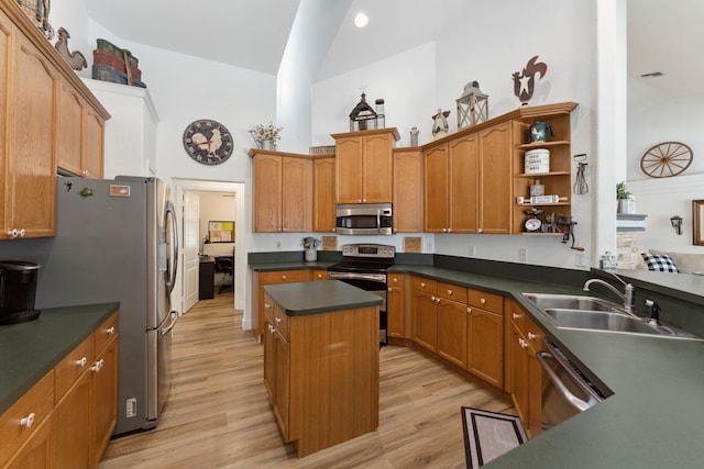 kitchen with sink, stainless steel appliances, light hardwood / wood-style floors, lofted ceiling, and a kitchen island