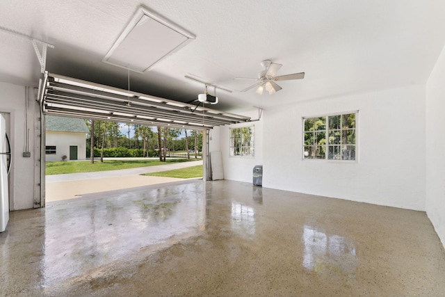 garage with ceiling fan, a garage door opener, and white refrigerator