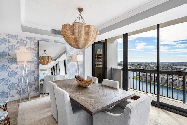 dining area featuring a water view and crown molding