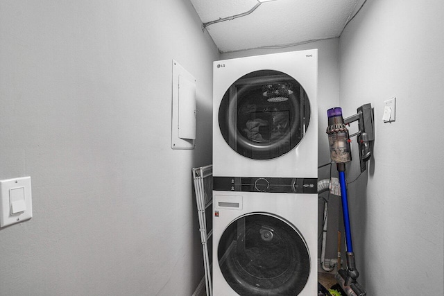 laundry area featuring a textured ceiling and stacked washer and clothes dryer