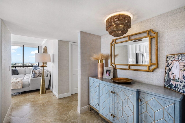 interior space featuring baseboards and a chandelier