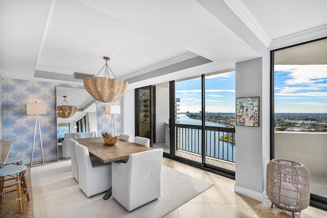 dining room with expansive windows, a water view, and a wealth of natural light