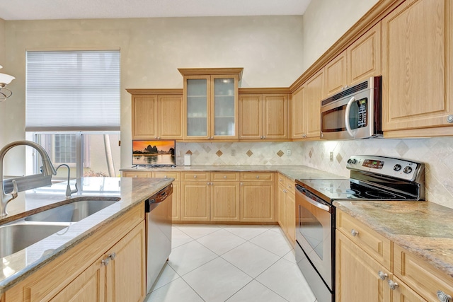 kitchen featuring light tile patterned flooring, stainless steel appliances, tasteful backsplash, and sink