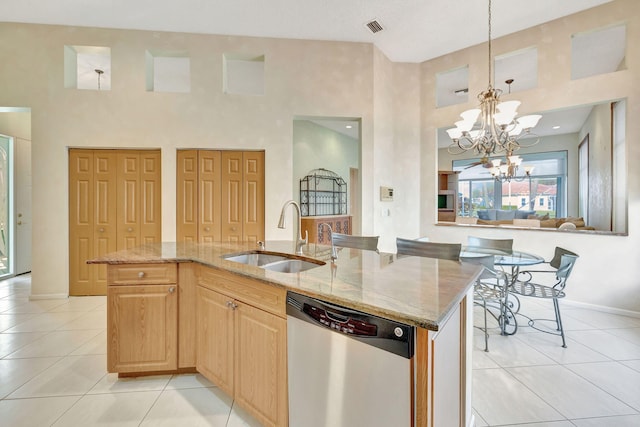 kitchen featuring an island with sink, an inviting chandelier, stainless steel dishwasher, and sink