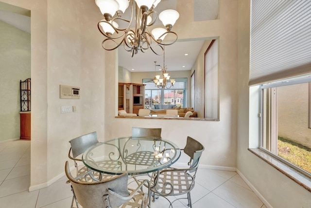 tiled dining room featuring an inviting chandelier and a healthy amount of sunlight