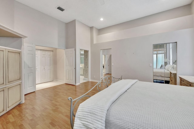 bedroom with connected bathroom, a closet, and light hardwood / wood-style flooring