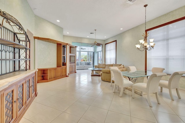 tiled dining room with ceiling fan with notable chandelier